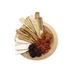 A wooden plate arranged with various dried herbal ingredients, including slices of white and tan roots, orange-brown pieces, dark red goji berries, and dark purple dried fruits, on a plain white background.