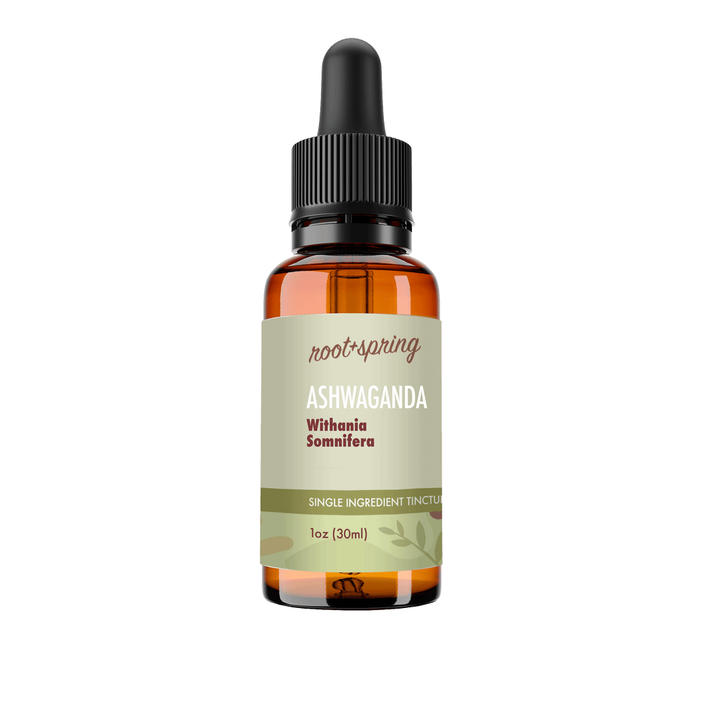 A 1 oz amber glass dropper bottle of Root+Spring Ashwaganda tincture with a black dropper cap and a light olive-green label, shown on a transparent background.